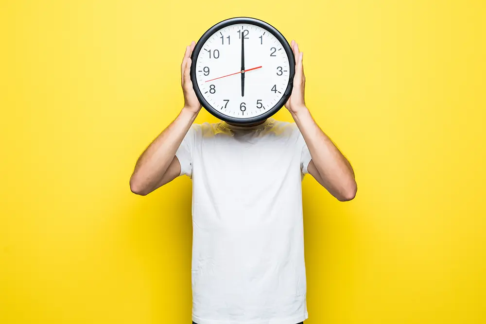 handsome-man-in-white-t-shirt-and-transperent-glasses-hold-big-clock-in-place-of-his-head copie