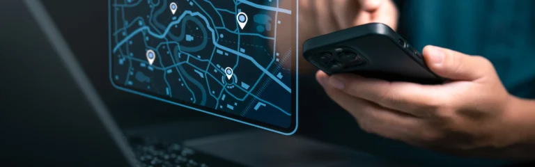 un homme tenant un téléphone qui lui donne accès aux informations de géolocalisation des véhicules