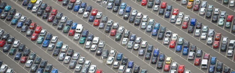 Vue aérienne d’un grand parking rempli de voitures, illustrant la gestion et l’optimisation d’une flotte automobile d’entreprise.