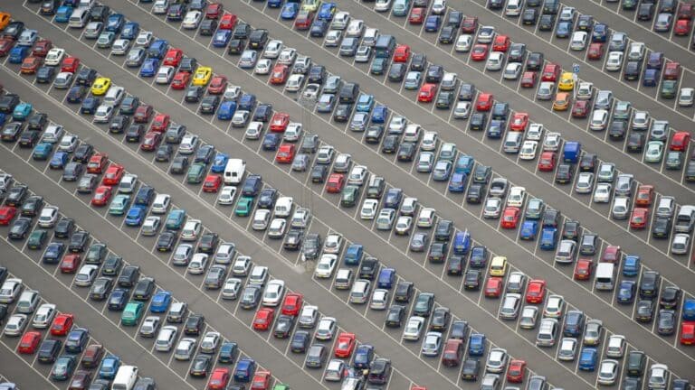 Vue aérienne d’un grand parking rempli de voitures, illustrant la gestion et l’optimisation d’une flotte automobile d’entreprise.