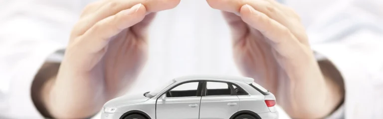 Main protectrice couvrant une voiture miniature, symbolisant la protection automobile