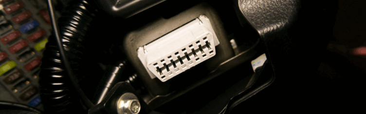 Vue rapprochée d’une prise OBD dans un véhicule, illustrant les méthodes d’installation des boîtiers de télématique embarquée via bus CAN et OBD.