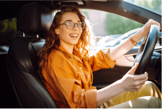 autopartage-entreprise-mobilite-professionnelle-ocean.png Conductrice souriante au volant d’un véhicule, illustrant l’autopartage en entreprise et la mobilité professionnelle.