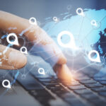 Gps point navigation concept with virtual world map and white pins location on human hand typing on laptop keyboard background