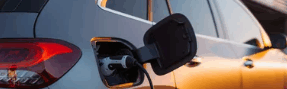 Recharge d’un véhicule électrique sur une borne en entreprise au coucher du soleil.