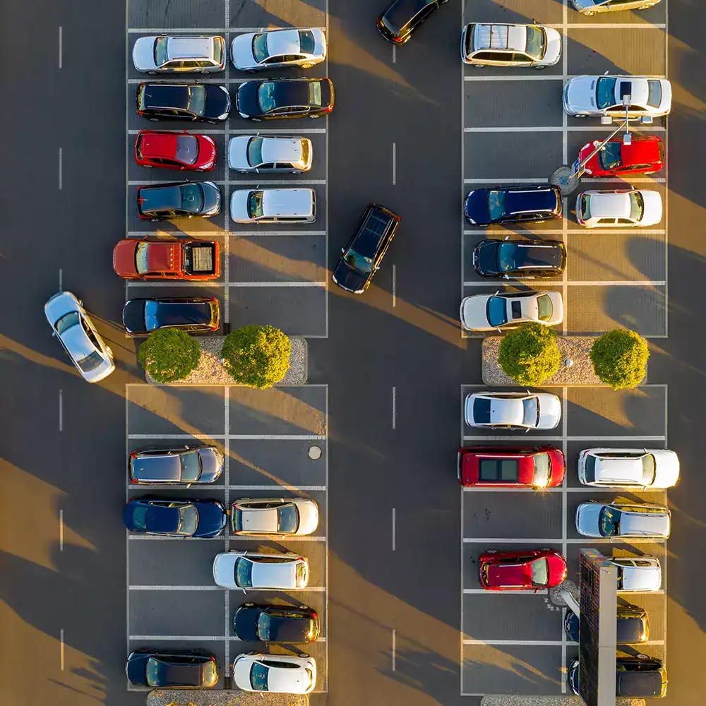 vue-aerienne-parking-flotte-vehicules-entreprise-ocean.webp Vue aérienne d’un parking avec plusieurs véhicules d’entreprise stationnés, illustrant la gestion et l’optimisation d’une flotte automobile.